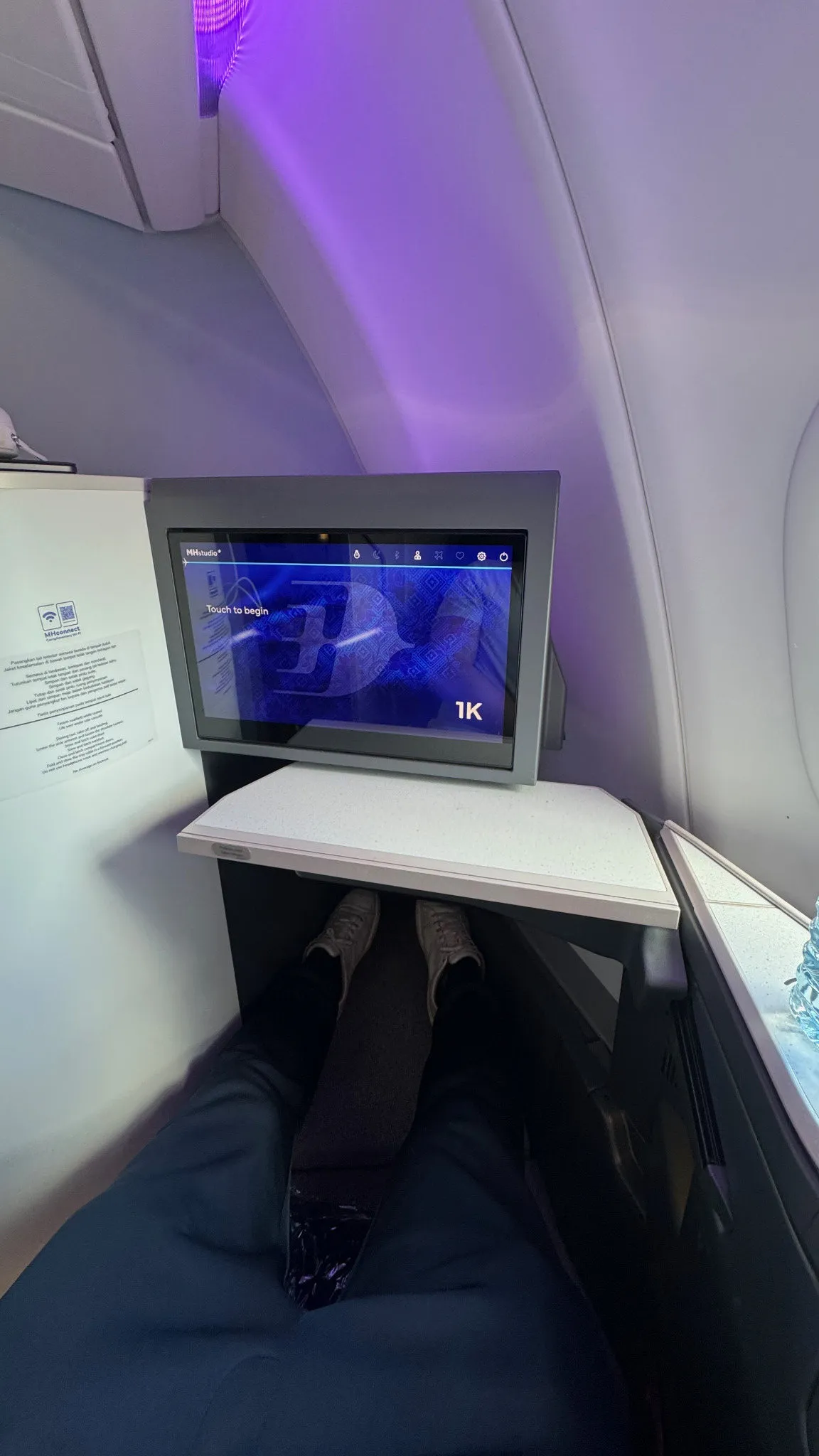 My legroom in seat 1K, looking toward the footwell, ottoman and screen.