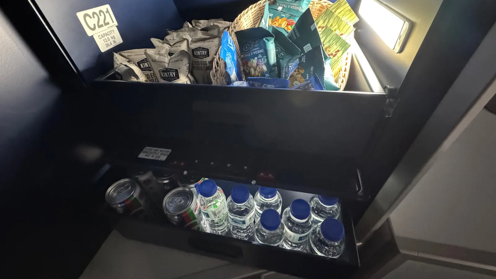 The galley snack drawer, stocked with snacks and bottled water.