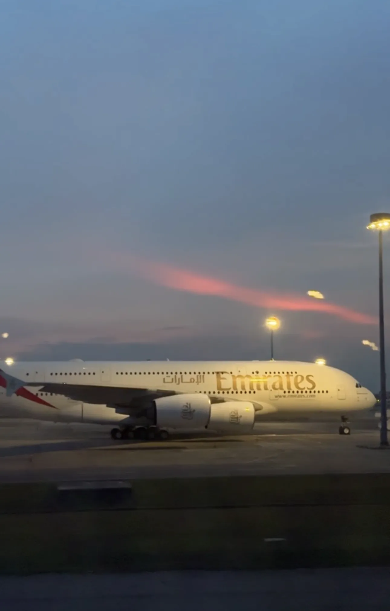 An Emirates A380 taxiing at Kuala Lumpur International Airport at dusk