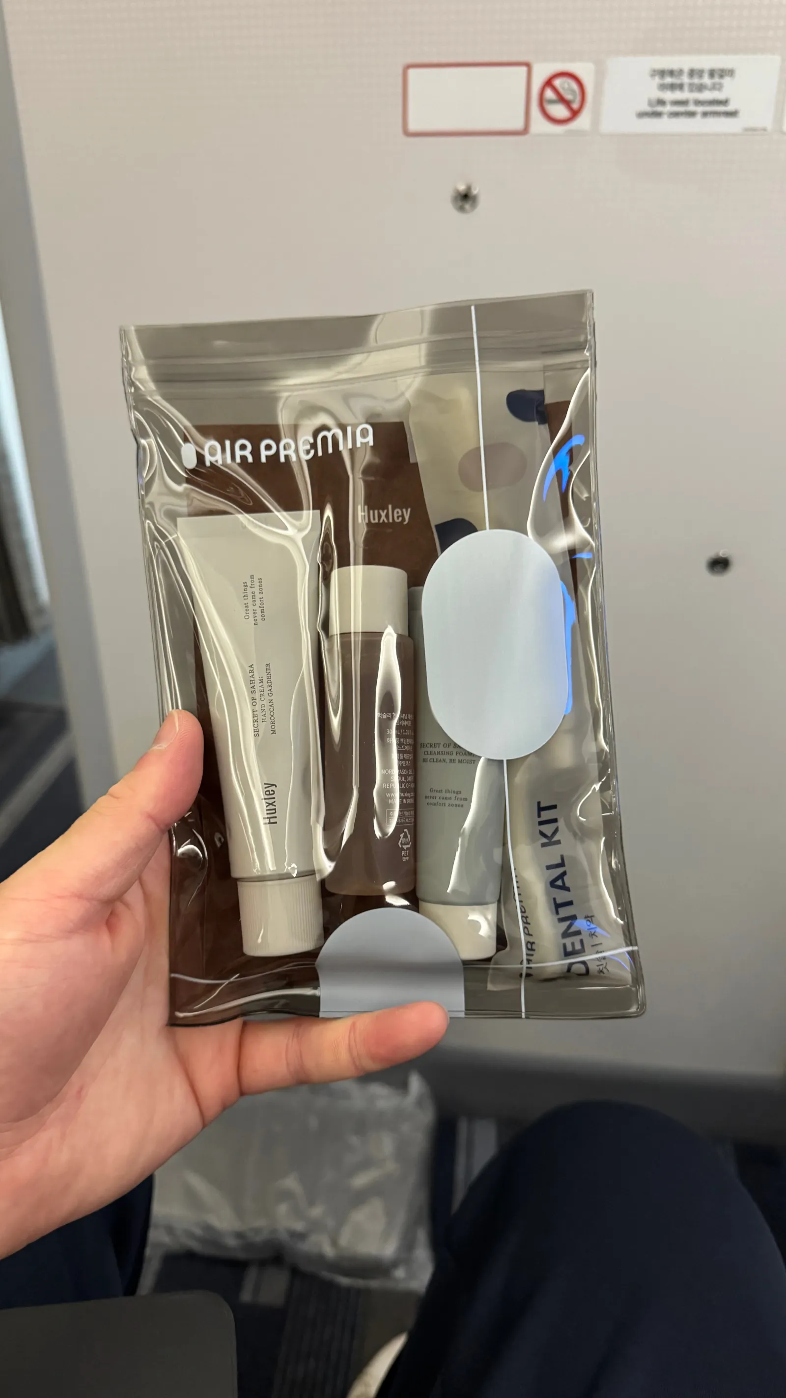 The Huxley skincare and dental amenity kit — including a face mask.