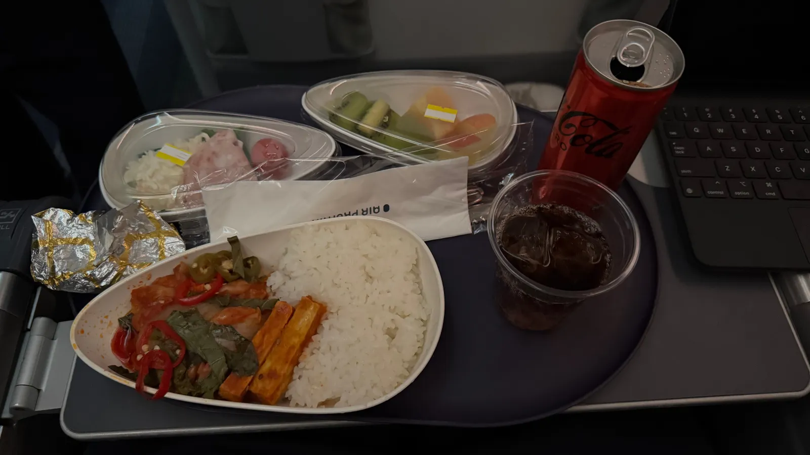 Second meal: spicy Korean pork with rice, fruit, and accompanying sides.